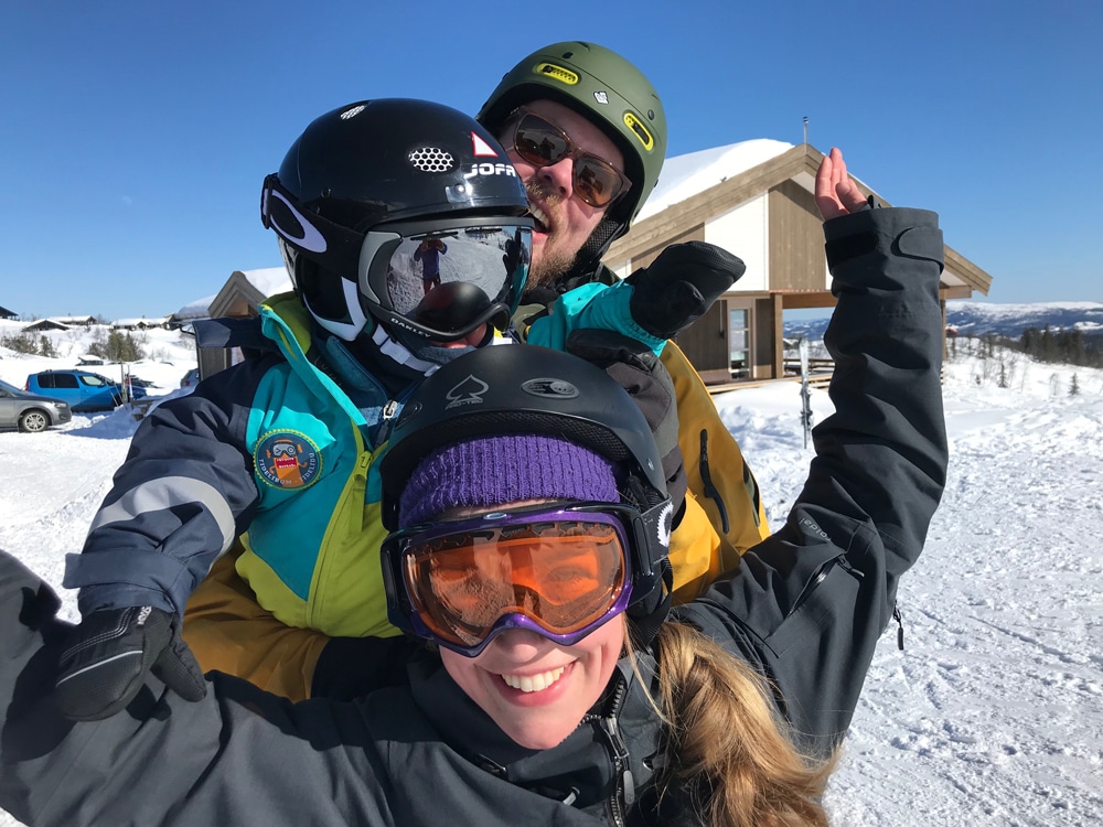 foreldre ute på slalom, med sønn på ryggen