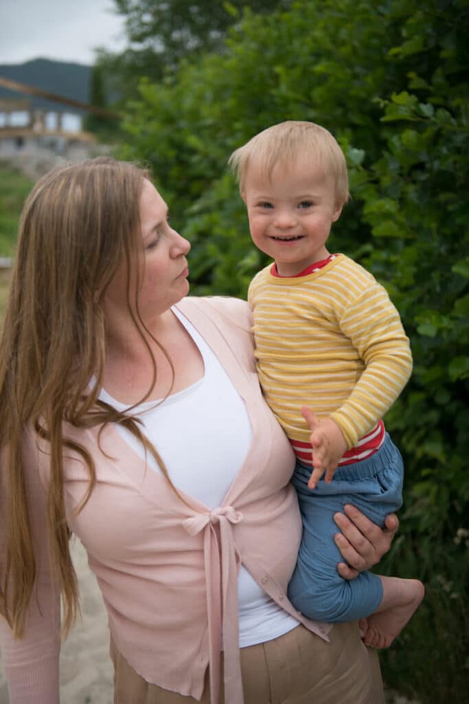 Bilde av styreleder i NNDS, Randi Ødegaard med hennes sønn med Downs syndrom på armen