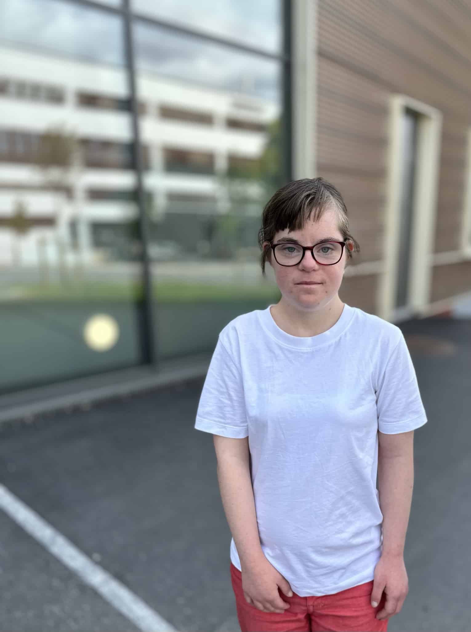Kvinne med Downs syndrom som står utenfor en bygning