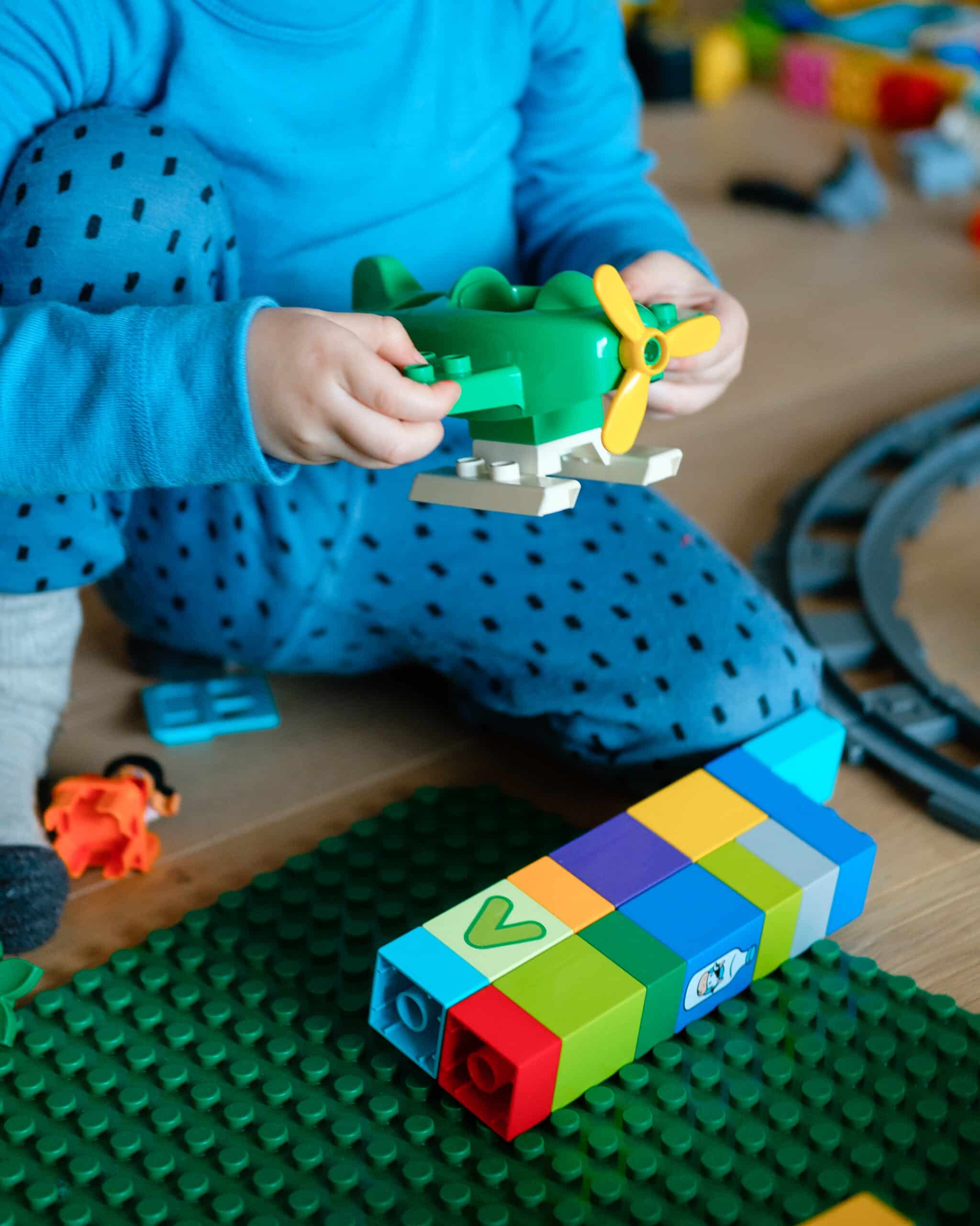 barn leker med lego på gulv