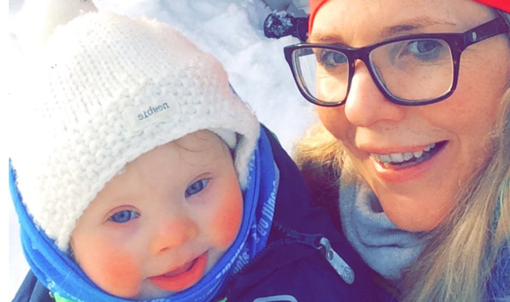 mor holder sønn med downs syndrom i armene ute i snøen