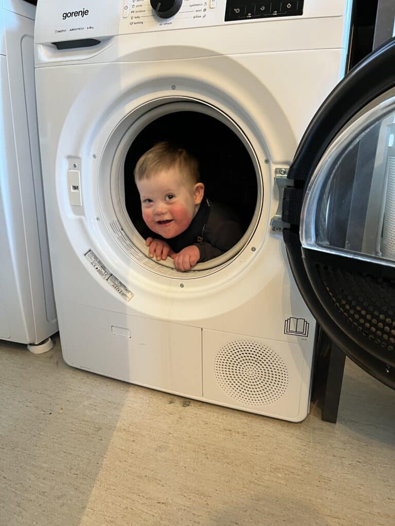 Edvard med Downs syndrom sitter inne i trommelen i vaskemaskinen