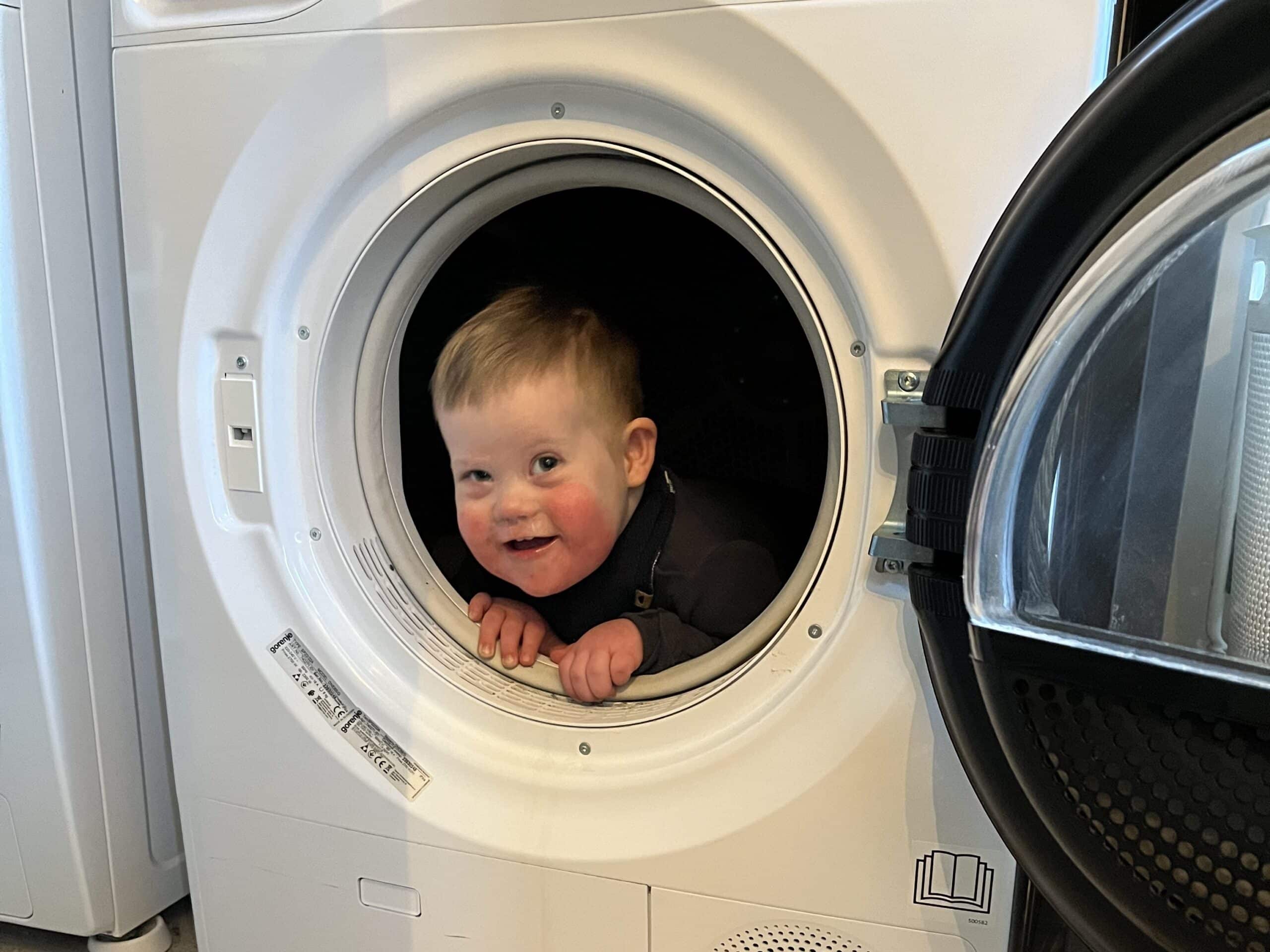 Edvard med Downs syndrom sitter inne i trommelen i vaskemaskinen
