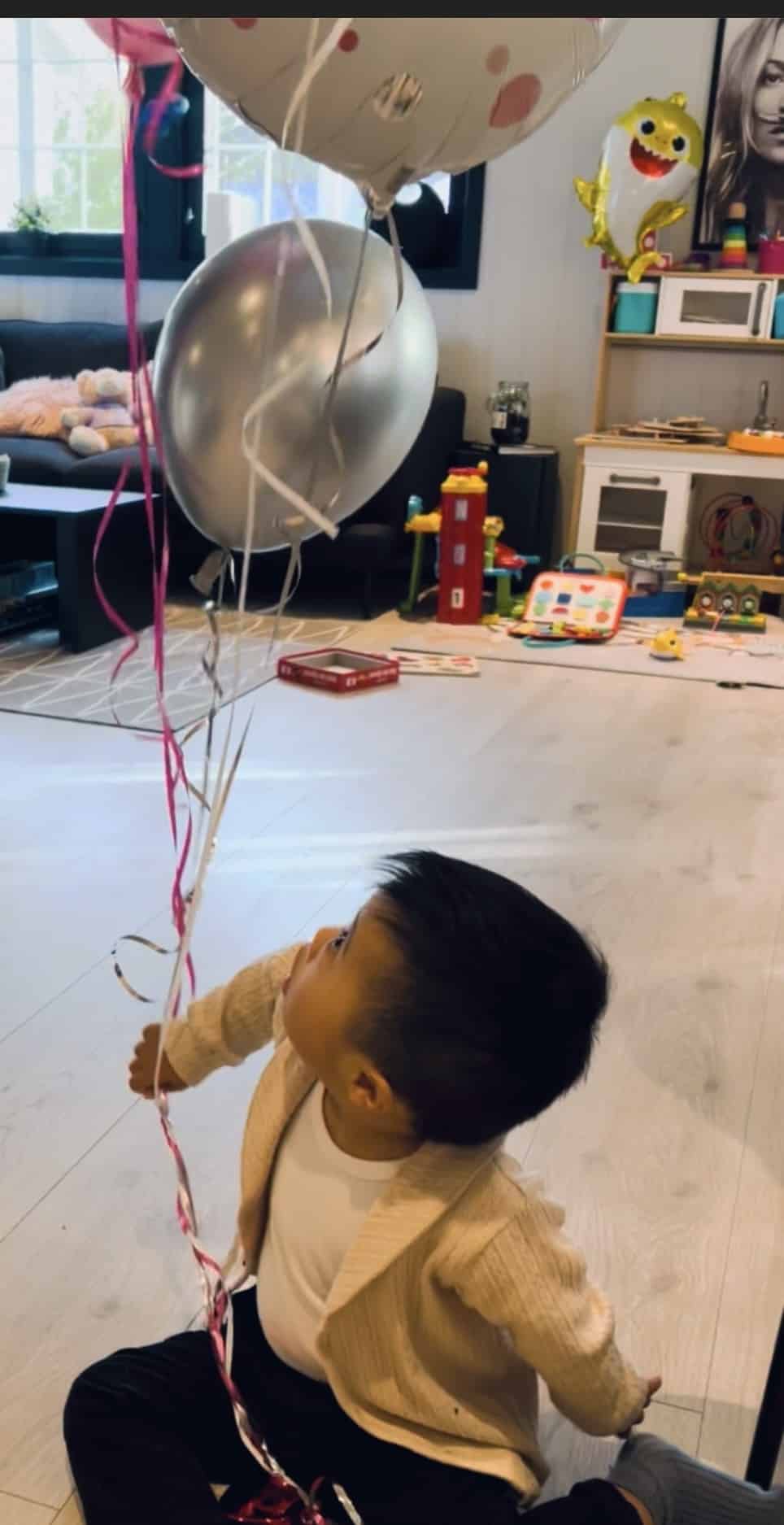 Liten gutt som holder ballonger