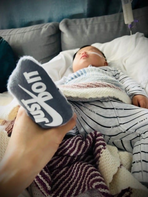 Liten baby med sokk der det står "just do it"