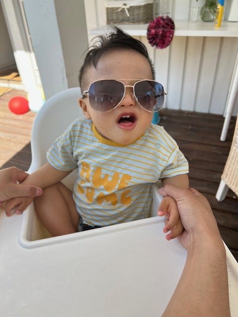 Liten gutt med solbriller som sitter i babystol