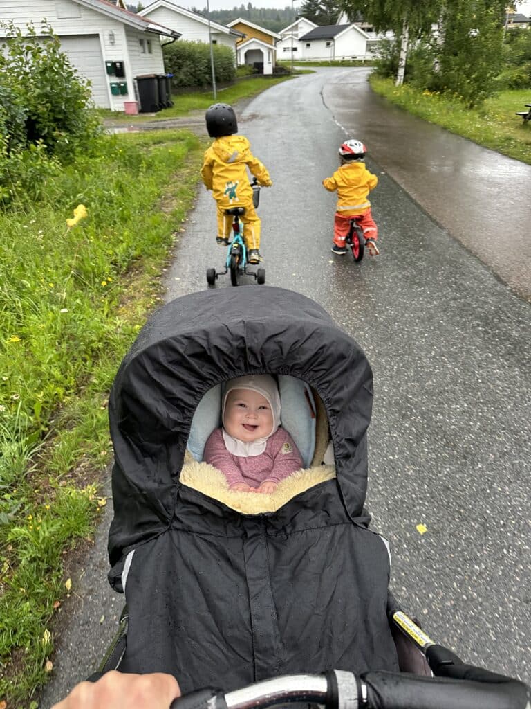 Baby på trilletur sammen med to små barn på sykkel