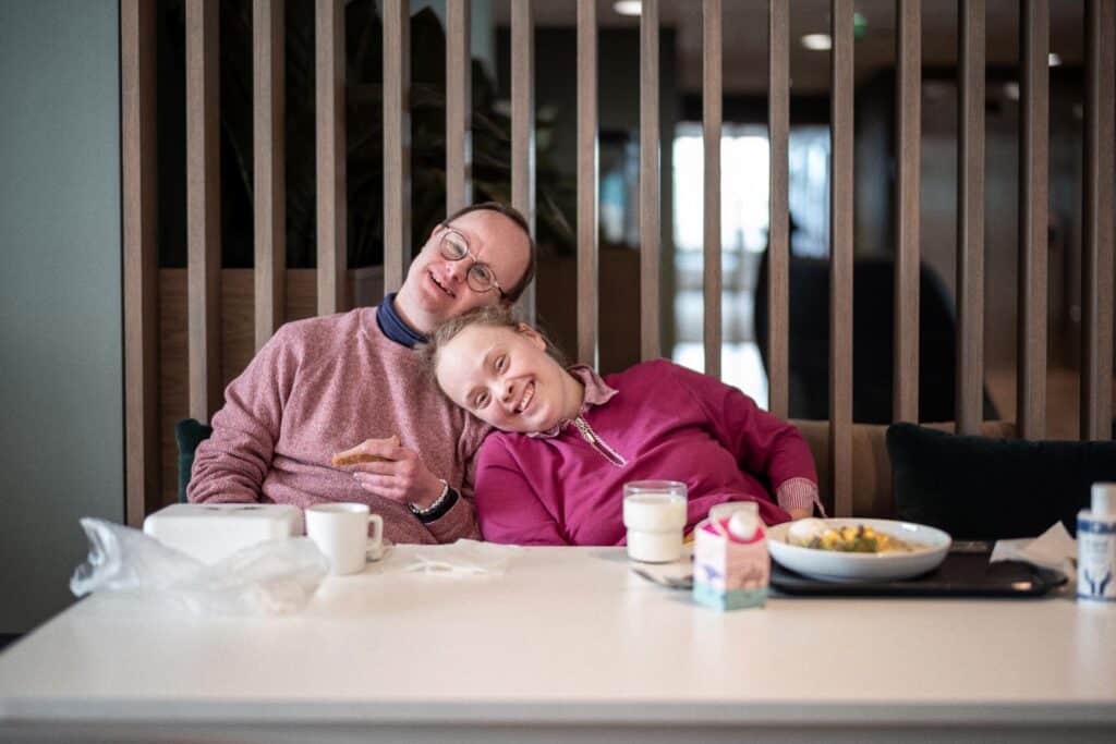 Mann og kvinne med Downs syndrom som spiser lunsj sammen