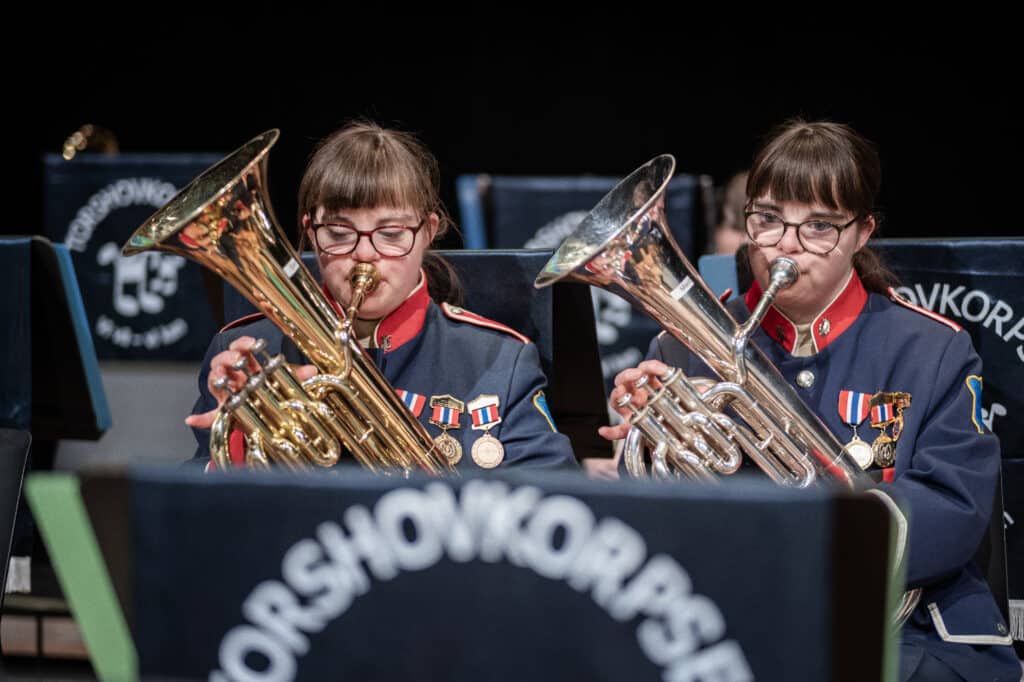 Tvillinger med Downs syndrom som spiller i korps på hvert sitt blåseinstrument