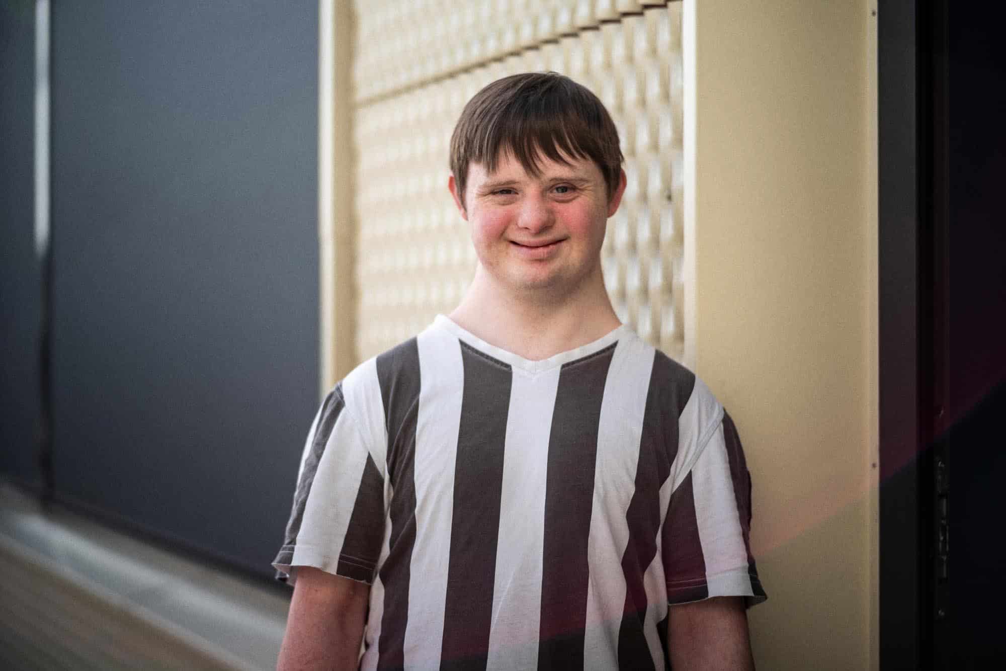 Portrett av ung mann med Downs syndrom som smiler