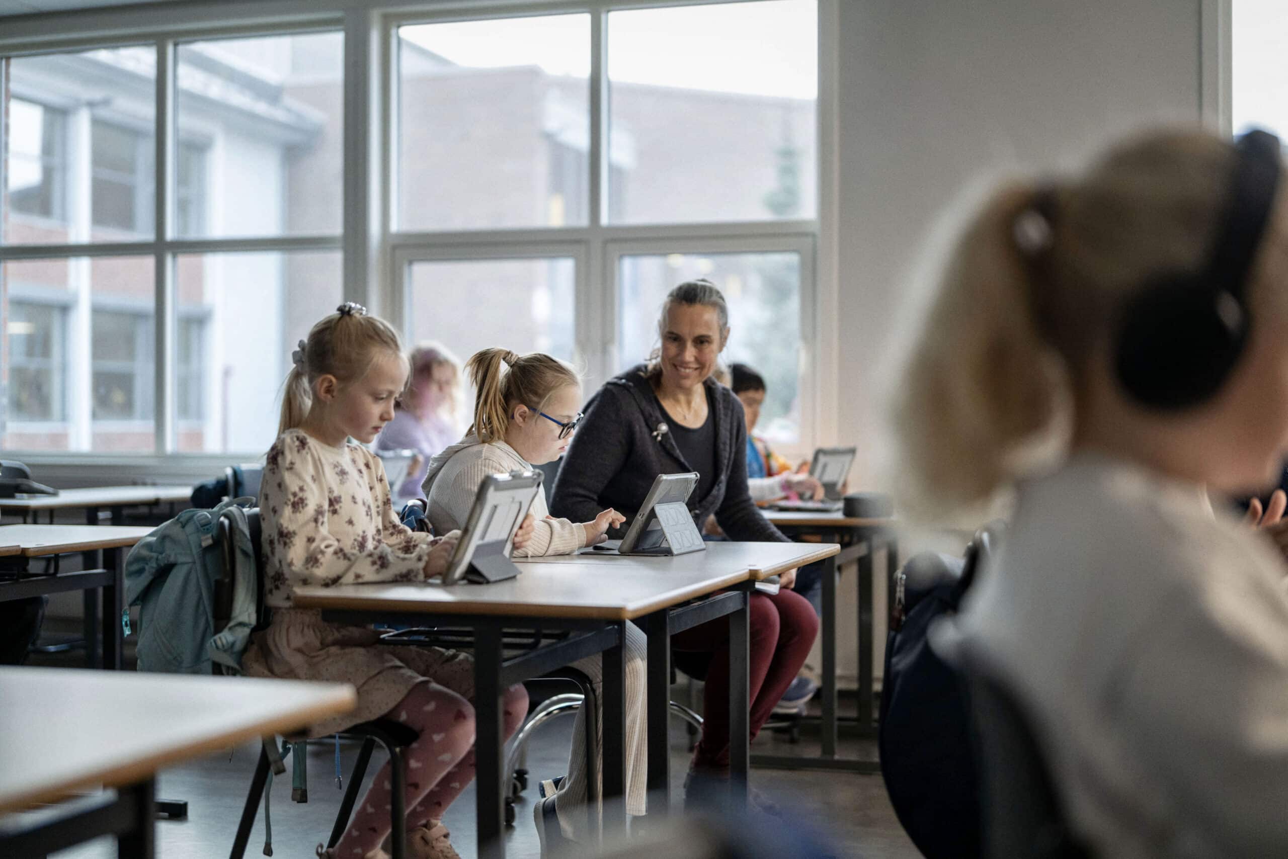 Elever i et klasserom som jobber på iPad.