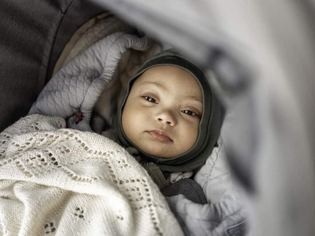 Baby med Downs syndrom som ligger i vogn