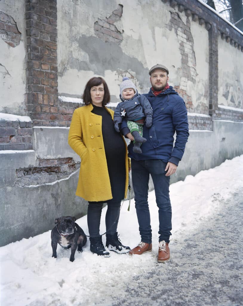 Familie med to voksne, et barn og en hund. Barnet har Downs syndrom.