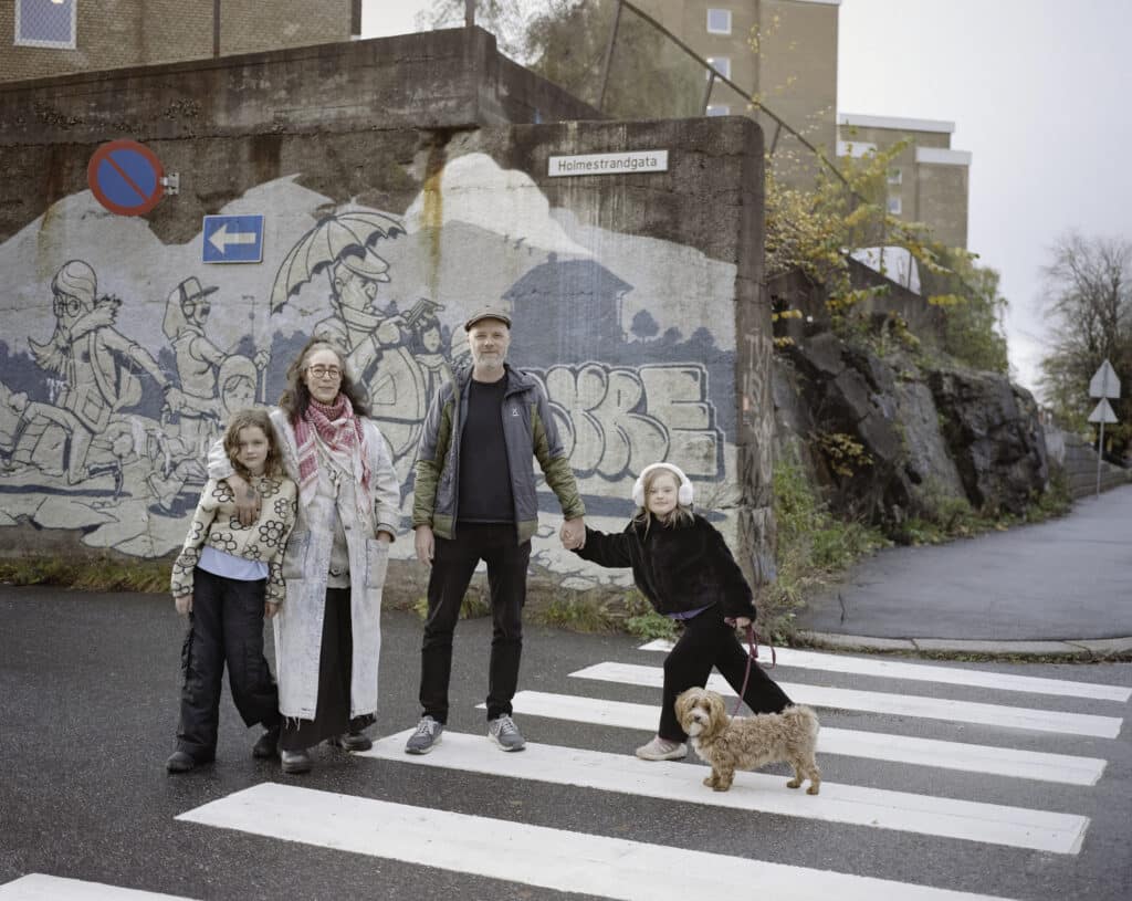 Familie med to voksne og to barn og en hund. Et av barna har Downs syndrom.