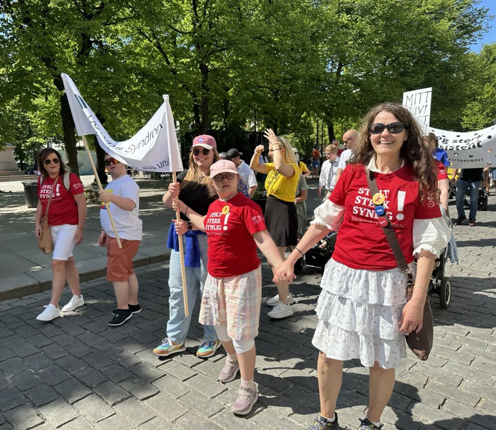 Mor og datter som går i parade sammen med andre